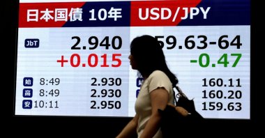 A passerby walks past a screen (L) showing the yield on the 10-year Japanese government bond, Tokyo, Japan, Aug. 31, 2026. (EPA Photo)