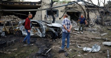 Residents stand near cars burned after a Russian missile strike in the town of Boryspil, in Kyiv region, Ukraine, Sept. 1, 2026. (Reuters Photo)
