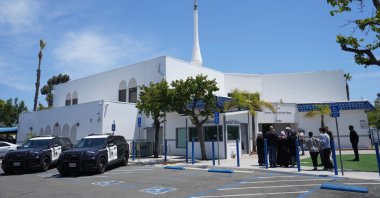 People gather as police vehicles are parked outside of the Islamic Center of San Diego, the day after a shooting, in San Diego, U.S., May 19, 2026. (AP Photo)