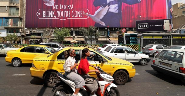 Commuters make their way past a billboard installed on a building along a busy street in downtown of Tehran, Aug. 31, 2026. (AFP Photo)
