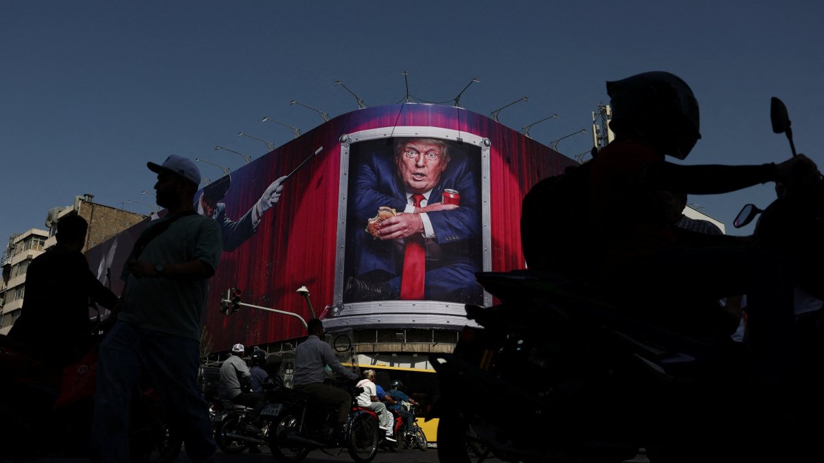 People walk near a billboard depicting U.S. President Donald Trump on a building in Tehran, Iran, Sept. 2, 2026. (Reuters Photo)