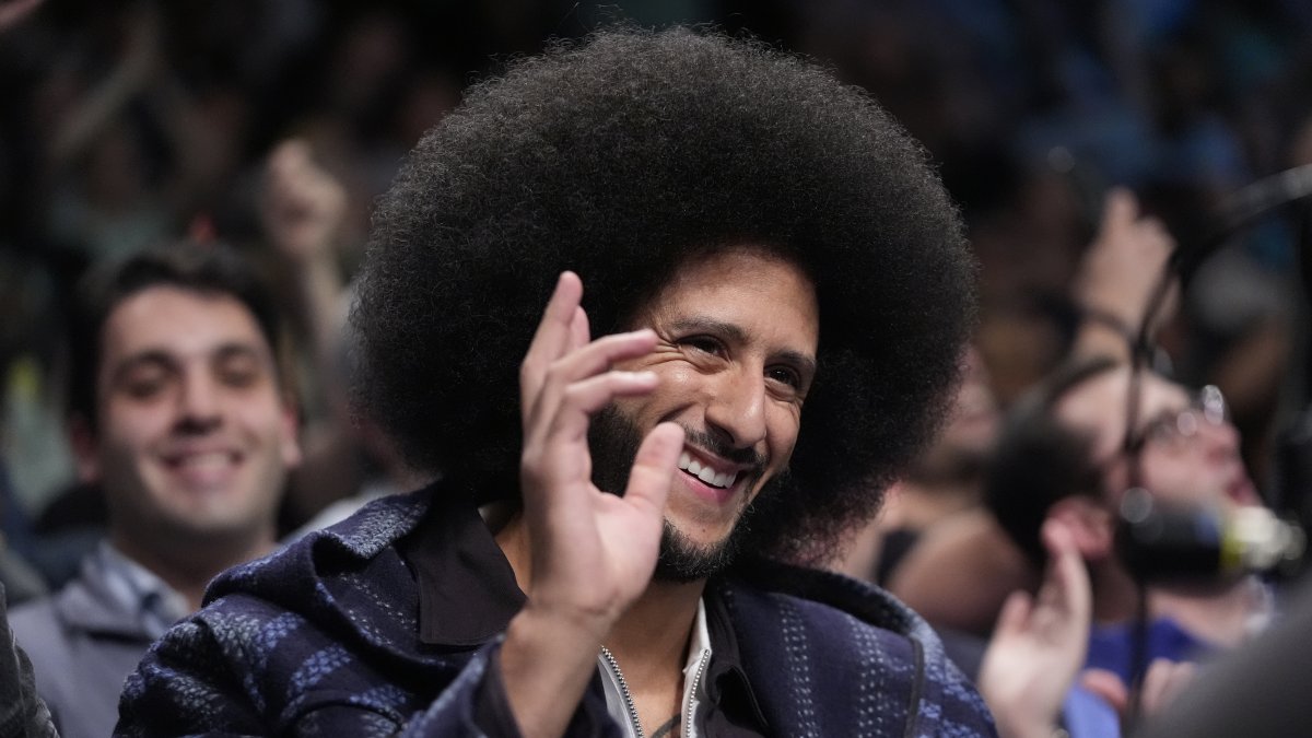 Colin Kaepernick gestures to fans during the second half of a WNBA basketball semifinal game between the New York Liberty and the Las Vegas Aces, New York, U.S., Oct. 1, 2024. (AP Photo)