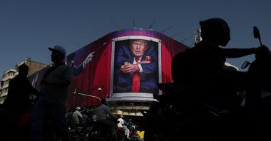 People walk near a billboard depicting U.S. President Donald Trump on a building in Tehran, Iran, Sept. 2, 2026. (Reuters Photo)