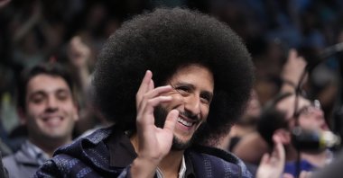 Colin Kaepernick gestures to fans during the second half of a WNBA basketball semifinal game between the New York Liberty and the Las Vegas Aces, New York, U.S., Oct. 1, 2024. (AP Photo)