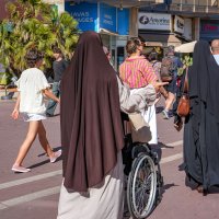 Two Muslim women walk among numerous passersby in Montpellier, southern France, Aug. 7, 2026. (AFP Photo)