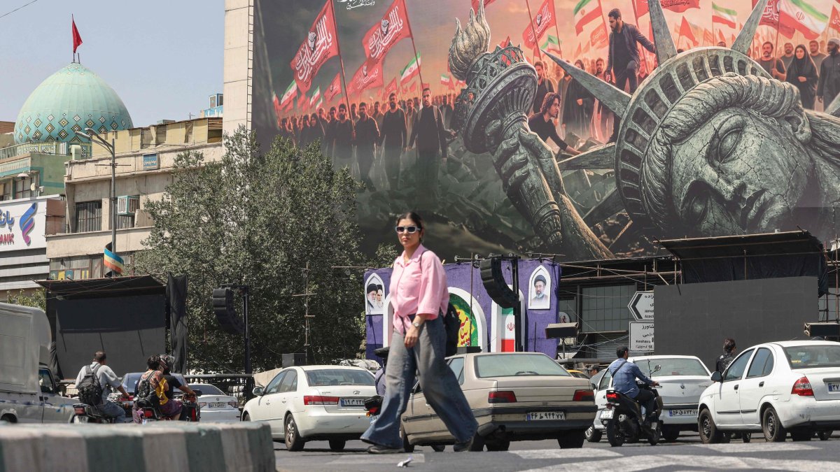 People walk past an anti-U.S. billboard at Enqelab Square in central Tehran, Iran, Sept. 2, 2026. (AFP Photo)