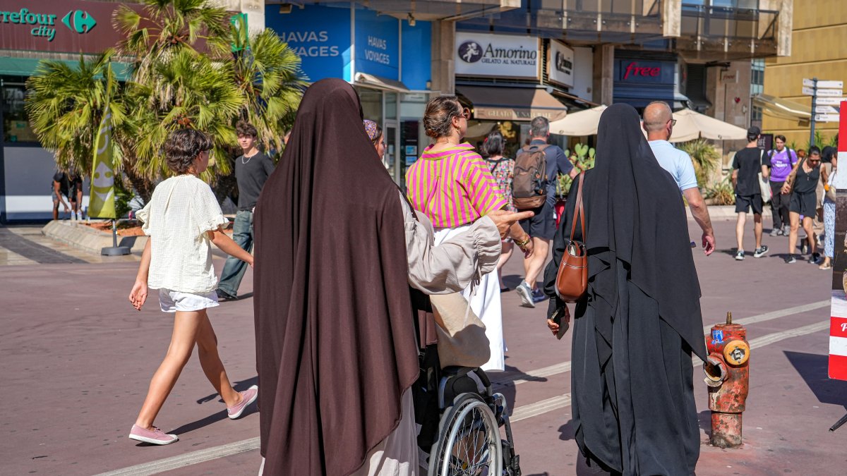 Two Muslim women walk among numerous passersby in Montpellier, southern France, Aug. 7, 2026. (AFP Photo)