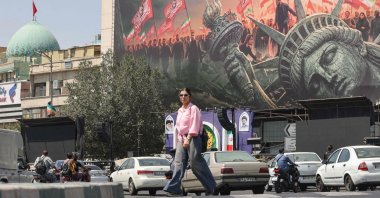 People walk past an anti-U.S. billboard at Enqelab Square in central Tehran, Iran, Sept. 2, 2026. (AFP Photo)