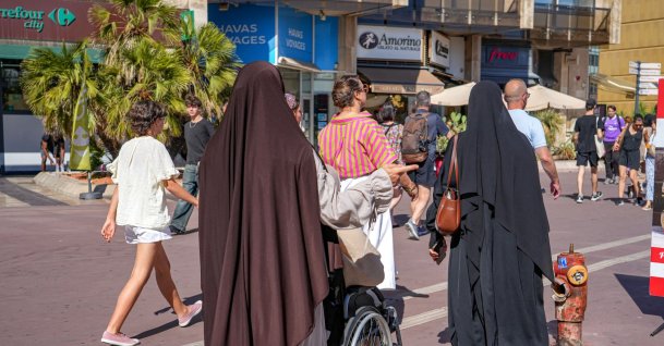 Two Muslim women walk among numerous passersby in Montpellier, southern France, Aug. 7, 2026. (AFP Photo)