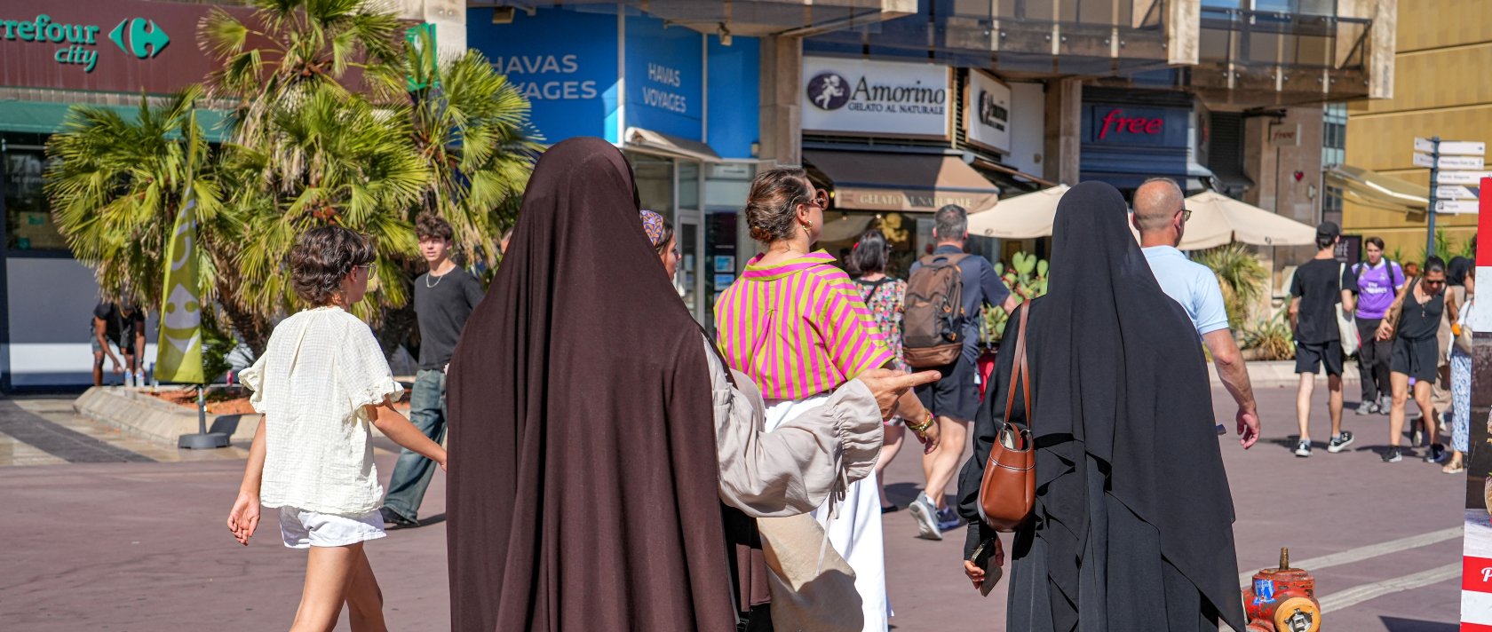 Two Muslim women walk among numerous passersby in Montpellier, southern France, Aug. 7, 2026. (AFP Photo)