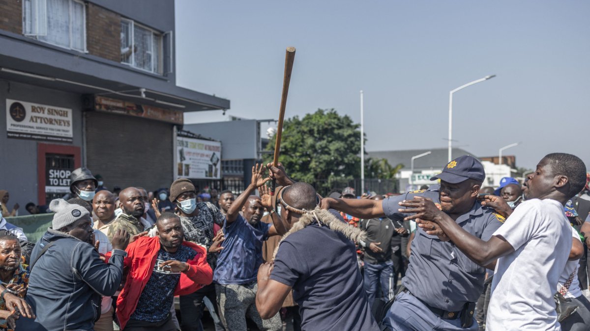 A South African Police Service (SAPS) officer (2nd R) tries to restrain members of March and March Movement from clashing with a foreign national during a demonstration against undocumented migrants, Durban, South Africa, Sept. 3, 2026. (AFP Photo)