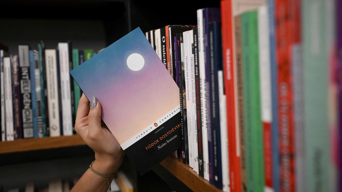 A bookseller gets a copy of the book "White Nights" of Russian writer Fyodor Dostoevsky from the shelf of the Leonardo Da Vinci bookstore, downtown Rio de Janeiro, Brazil, Aug. 28, 2026. (AFP Photo)
