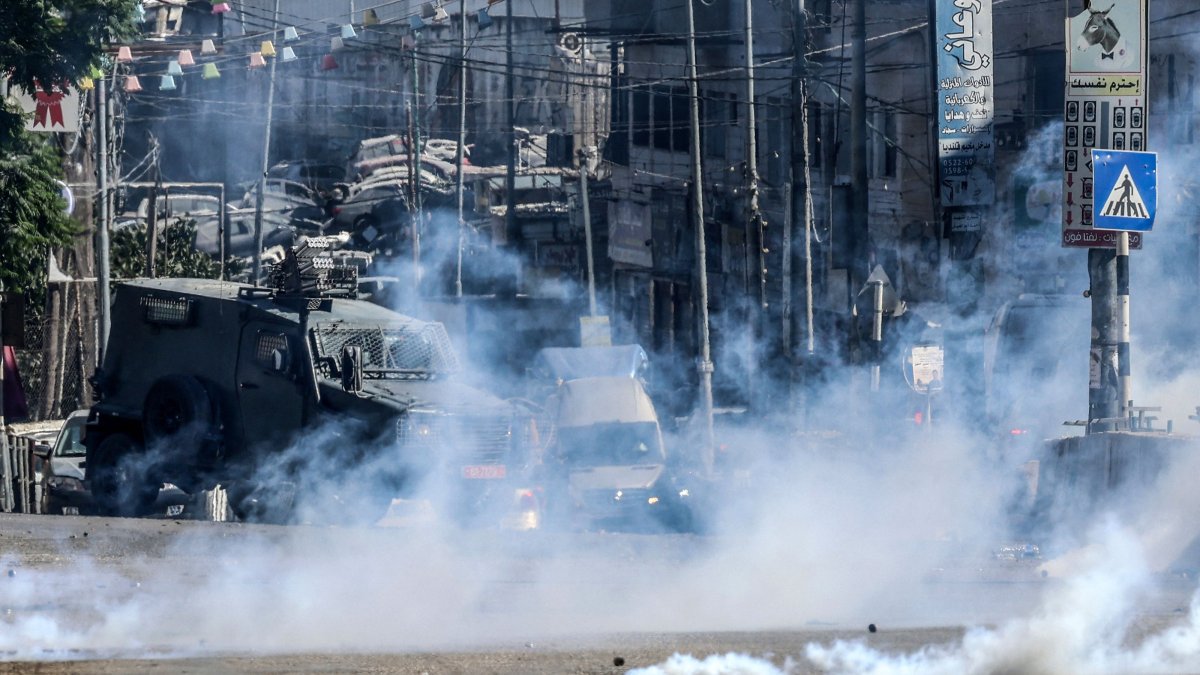 Israeli forces block a street and fire tear gas during an Israeli raid on the UNRWA Vocational Training Centre, located between the Kafr Aqab neighbourhood and the Qalandia refugee camp, south of the West Bank city of Ramallah, Aug. 25, 2026. (AFP Photo)