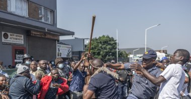 A South African Police Service (SAPS) officer (2nd R) tries to restrain members of March and March Movement from clashing with a foreign national during a demonstration against undocumented migrants, Durban, South Africa, Sept. 3, 2026. (AFP Photo)