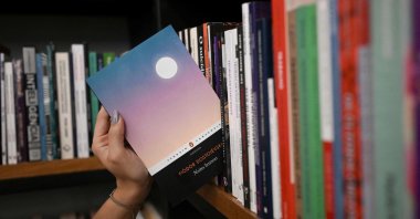 A bookseller gets a copy of the book "White Nights" of Russian writer Fyodor Dostoevsky from the shelf of the Leonardo Da Vinci bookstore, downtown Rio de Janeiro, Brazil, Aug. 28, 2026. (AFP Photo)