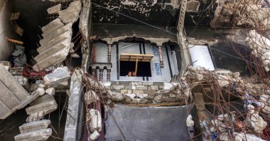 Children look out of the window of a makeshift shelter amidst the rubble of a heavily-damaged building in Khan Younis in the southern Gaza Strip, Aug. 25, 2026. (AFP Photo)