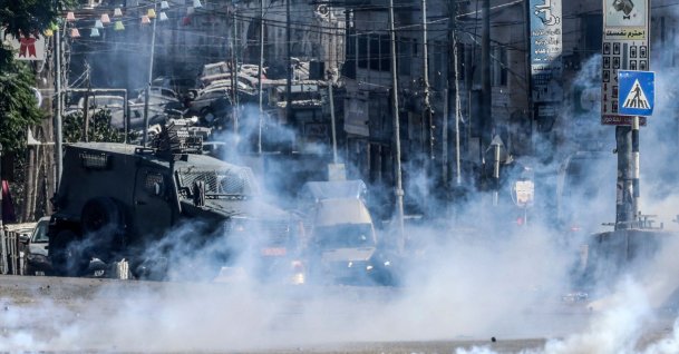 Israeli forces block a street and fire tear gas during an Israeli raid on the UNRWA Vocational Training Centre, located between the Kafr Aqab neighbourhood and the Qalandia refugee camp, south of the West Bank city of Ramallah, Aug. 25, 2026. (AFP Photo)