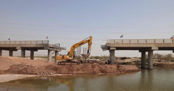 An excavator works on the Gachin Bridge, which was damaged by a U.S. strike, along the road between Bandar Abbas and Bandar Khamir, southern Iran, Aug. 11, 2026. (AFP Photo)