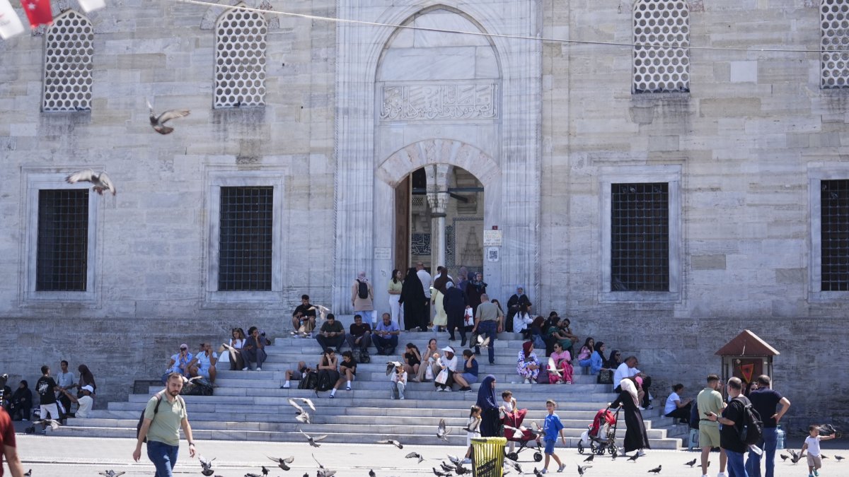 People are photographed in front of a mosque in Istanbul, Türkiye. (AA Photo)