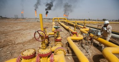A worker checks an oil pipeline at Nahr Bin Umar oil field, north of Basra, Iraq, March 22, 2022. (Reuters Photo)