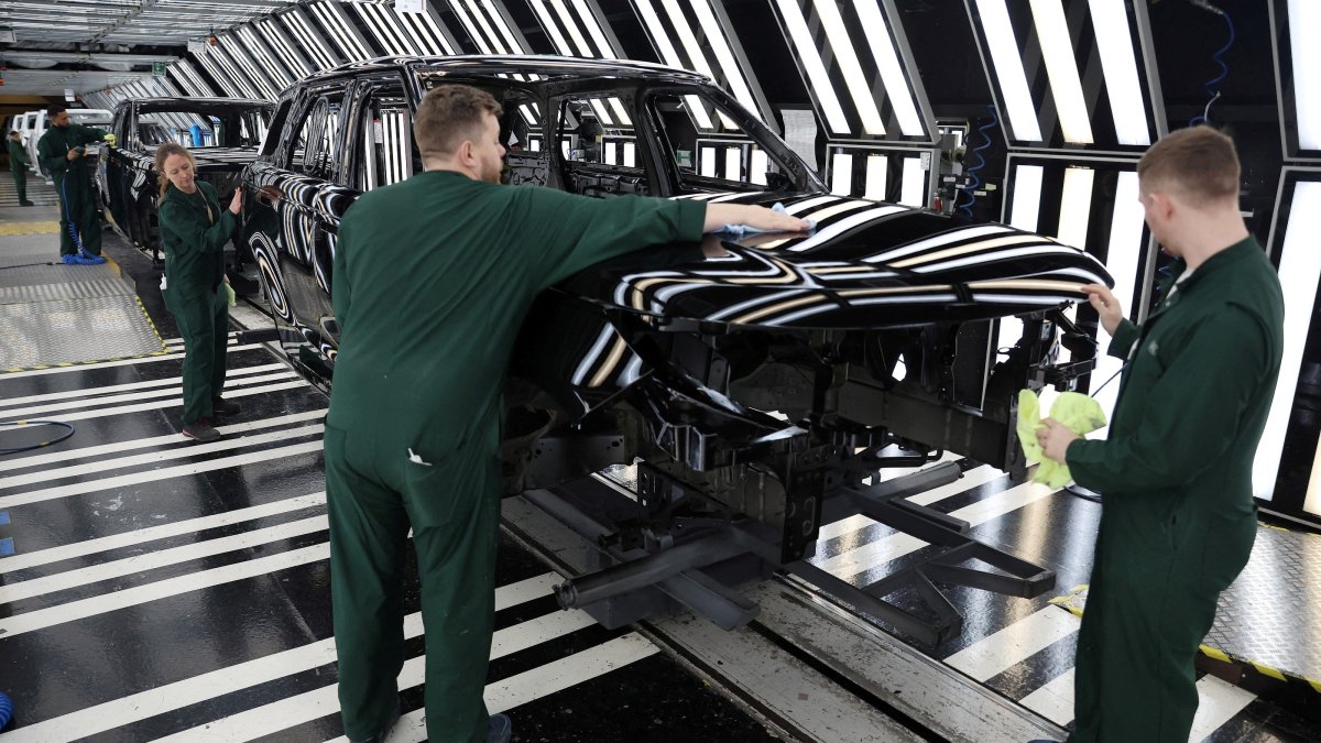 Members of staff check the paintwork on Range Rover bodies as they pass through the paint shop at Jaguar Land Rover's factory, Solihull, Britain, Dec. 15, 2022. (Reuters Photo)