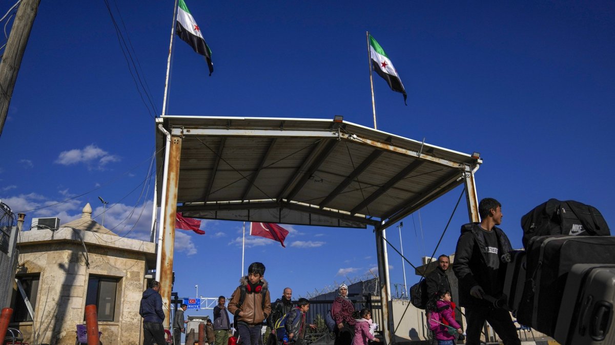 Syrians cross the border from Türkiye into Syria at the Bab al-Salama crossing gate, Syria, Dec. 13, 2024. (AP Photo)
