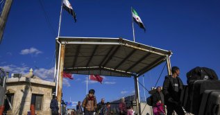 Syrians cross the border from Türkiye into Syria at the Bab al-Salama crossing gate, Syria, Dec. 13, 2024. (AP Photo)