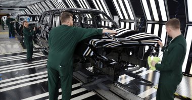 Members of staff check the paintwork on Range Rover bodies as they pass through the paint shop at Jaguar Land Rover's factory, Solihull, Britain, Dec. 15, 2022. (Reuters Photo)