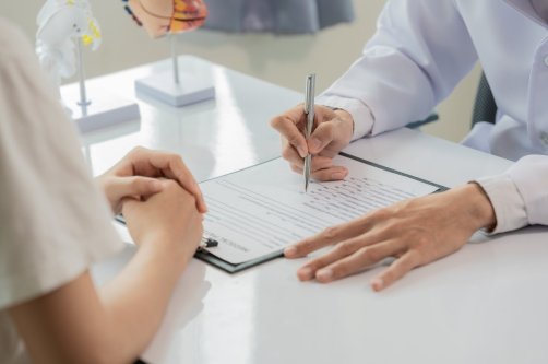 A doctor discusses a diagnosis with a patient during a consultation. (Shutterstock Photo)