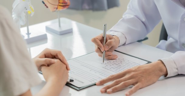 A doctor discusses a diagnosis with a patient during a consultation. (Shutterstock Photo)