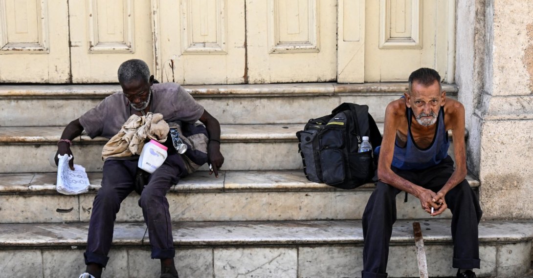 Homeless people sit on a street in Havana, July 21, 2025. (AFP File Photo)