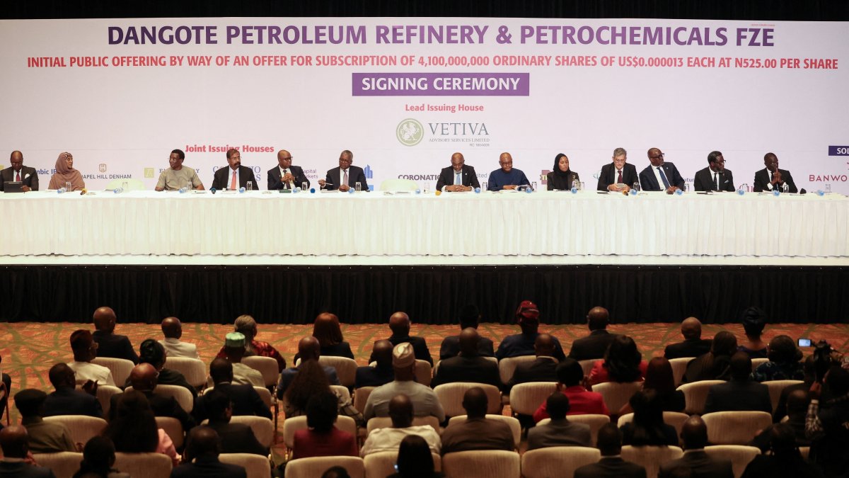 People sit in a hall as Aliko Dangote, president and CEO of Dangote Group, arrives for the signing ceremony for the Dangote Refinery initial public offering (IPO), Lagos, Nigeria, Sept. 7, 2026. (Reuters Photo)