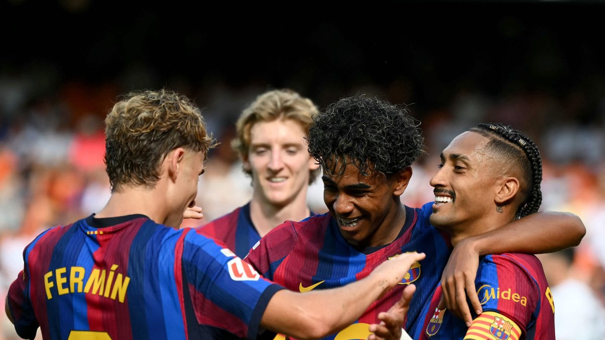 Barcelona's Raphinha (R) celebrates with Lamine Yamal and Fermin Lopez (L) after scoring his team's third goal during the La Liga match against Valencia at Mestalla Stadium, Valencia, Spain, Sept. 6, 2026. (AFP Photo)