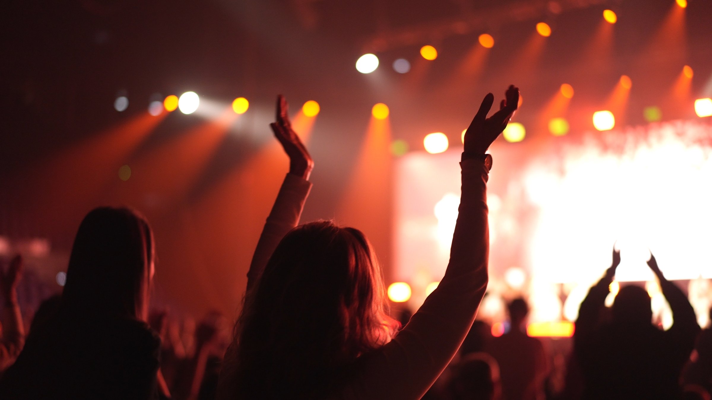 An enthusiastic audience cheers during a concert. (Shutterstock Photo)
