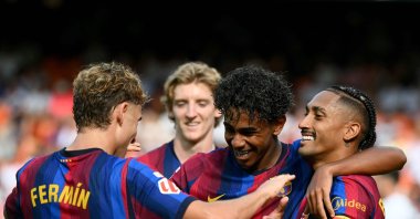 Barcelona's Raphinha (R) celebrates with Lamine Yamal and Fermin Lopez (L) after scoring his team's third goal during the La Liga match against Valencia at Mestalla Stadium, Valencia, Spain, Sept. 6, 2026. (AFP Photo)
