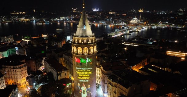A drone-captured aerial view shows the historic Galata Tower reflecting the images of the leaders of three members of the Mecca pact, Istanbul, Türkiye, Aug. 10, 2026. (AA Photo)