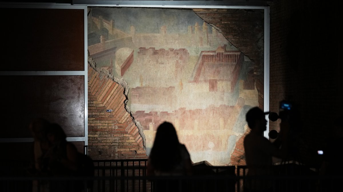 Reporters film the "The Painted City" fresco, discovered during 1990s built as foundations for the Baths of Trajan that has been restored, Rome, Italy, Sept. 8, 2026. (AP Photo)