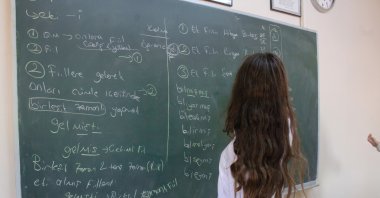 A student writes on the blackboard during a Turkish grammar class in a high school classroom, Istanbul, Türkiye, April 14, 2021. (Shutterstock Photo)