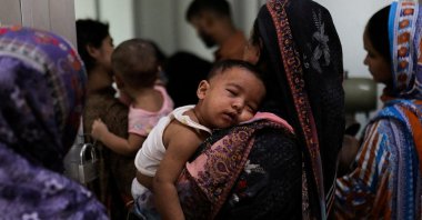 A woman carries a child, who suffers from measles, for treatment at a hospital in Dhaka, Bangladesh, Sept. 7, 2026. (Reuters Photo)