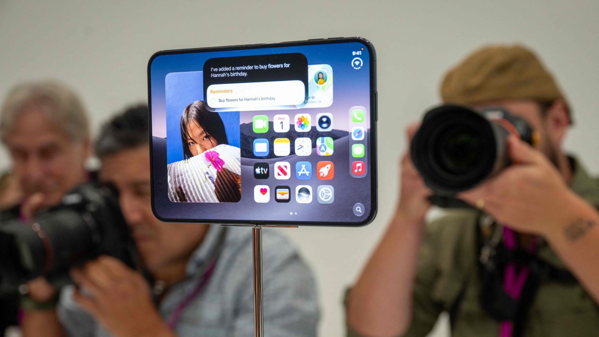 Journalists take photos of the new foldable iPhone Duo displayed during an Apple event at the Steve Jobs Theater in Apple Park, Cupertino, California, U.S., Sept. 9, 2026. (AFP Photo)