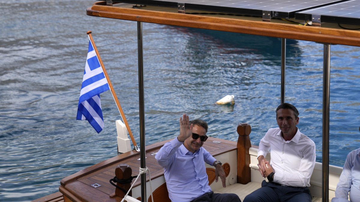 Greek Prime Minister Kyriakos Mitsotakis waves from a boat during his visit to the tiny Aegean island of Chalki, southeastern Greece, Friday, Nov. 5, 2021. (AP File Photo)