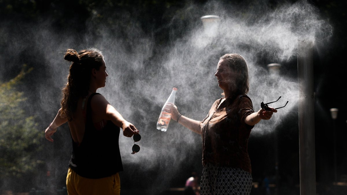 Women cool off under a misting system at Parc de Bercy during a heatwave in Paris, France, Aug. 14, 2026. (EPA Photo)