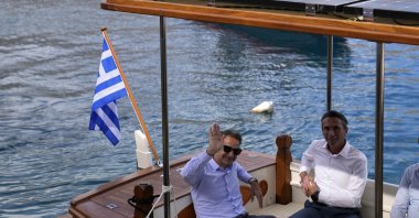 Greek Prime Minister Kyriakos Mitsotakis waves from a boat during his visit to the tiny Aegean island of Chalki, southeastern Greece, Friday, Nov. 5, 2021. (AP File Photo)