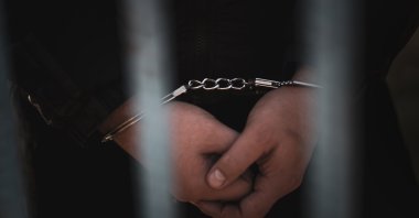 The handcuffed hands of a detainee. (Shutterstock Photo)