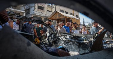 People gather around the vehicle destroyed in an Israeli attack that killed two people in Tel al-Hawa neighborhood of western Gaza City, Palestine, Sept. 13, 2026. (AA Photo)