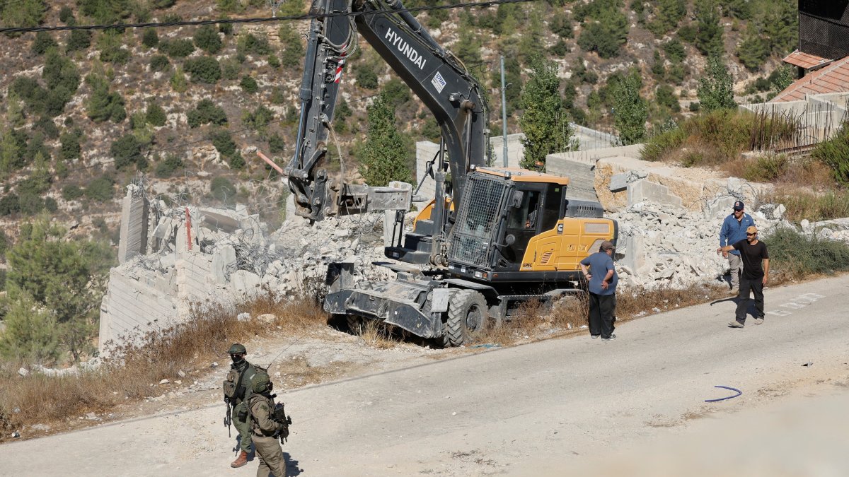 Israeli forces stand guard near heavy machinery during the demolition of a Palestinian building near Hebron in the Israeli-occupied West Bank, Palestine, Sept. 10, 2026. (Reuters Photo)