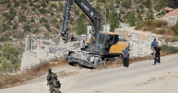 Israeli forces stand guard near heavy machinery during the demolition of a Palestinian building near Hebron in the Israeli-occupied West Bank, Palestine, Sept. 10, 2026. (Reuters Photo)