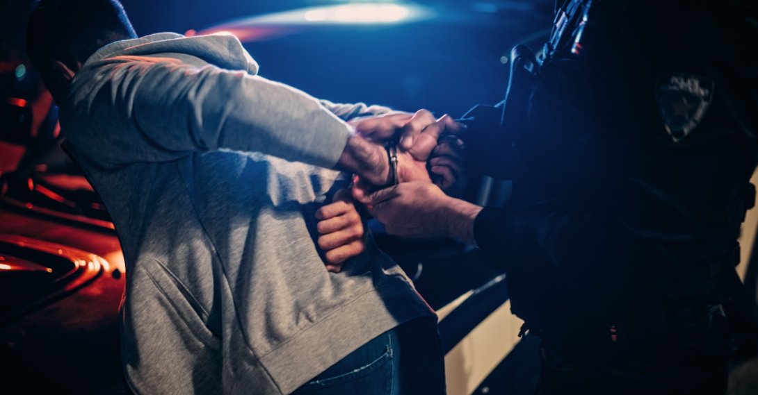 Police officers detain a suspect during an operation targeting criminal organizations. (Shutterstcok Photo)