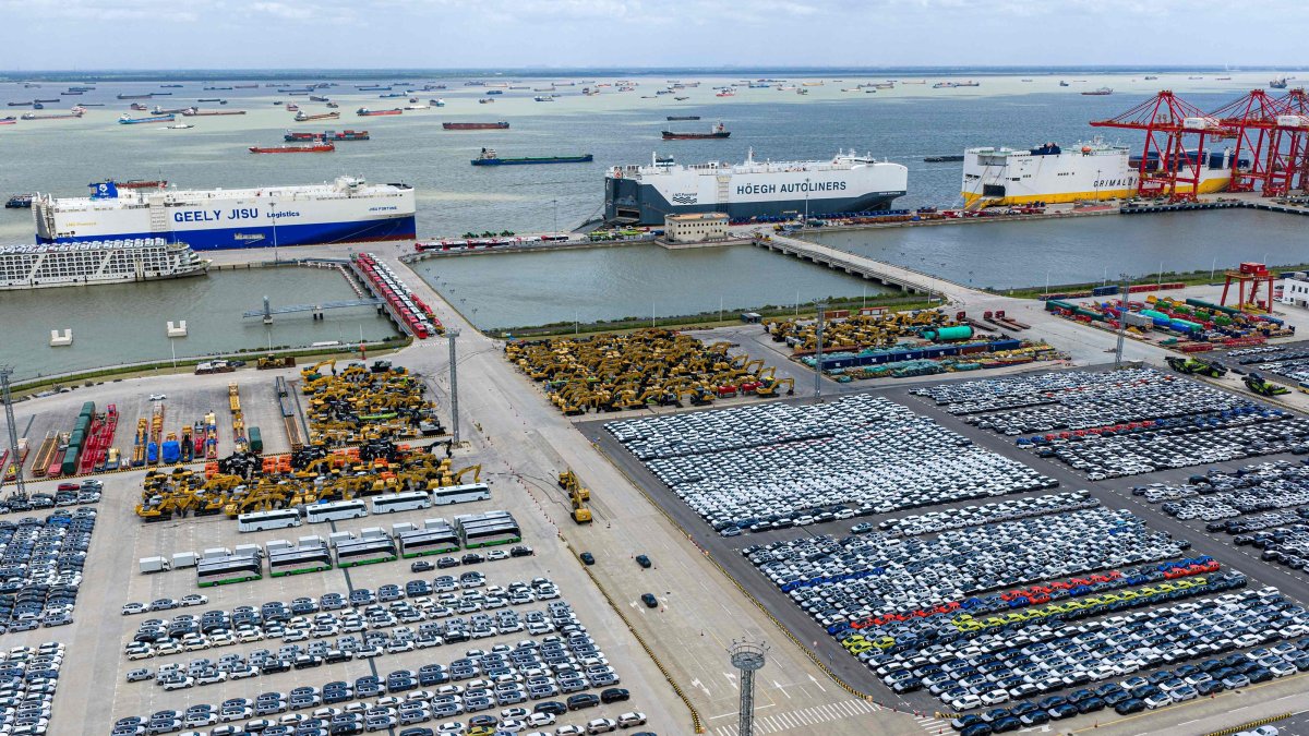Three specialized car transport ships are seen behind rows of cars waiting to be loaded at Suzhou port, eastern Jiangsu province, China, Sept. 9, 2026. (AFP Photo)