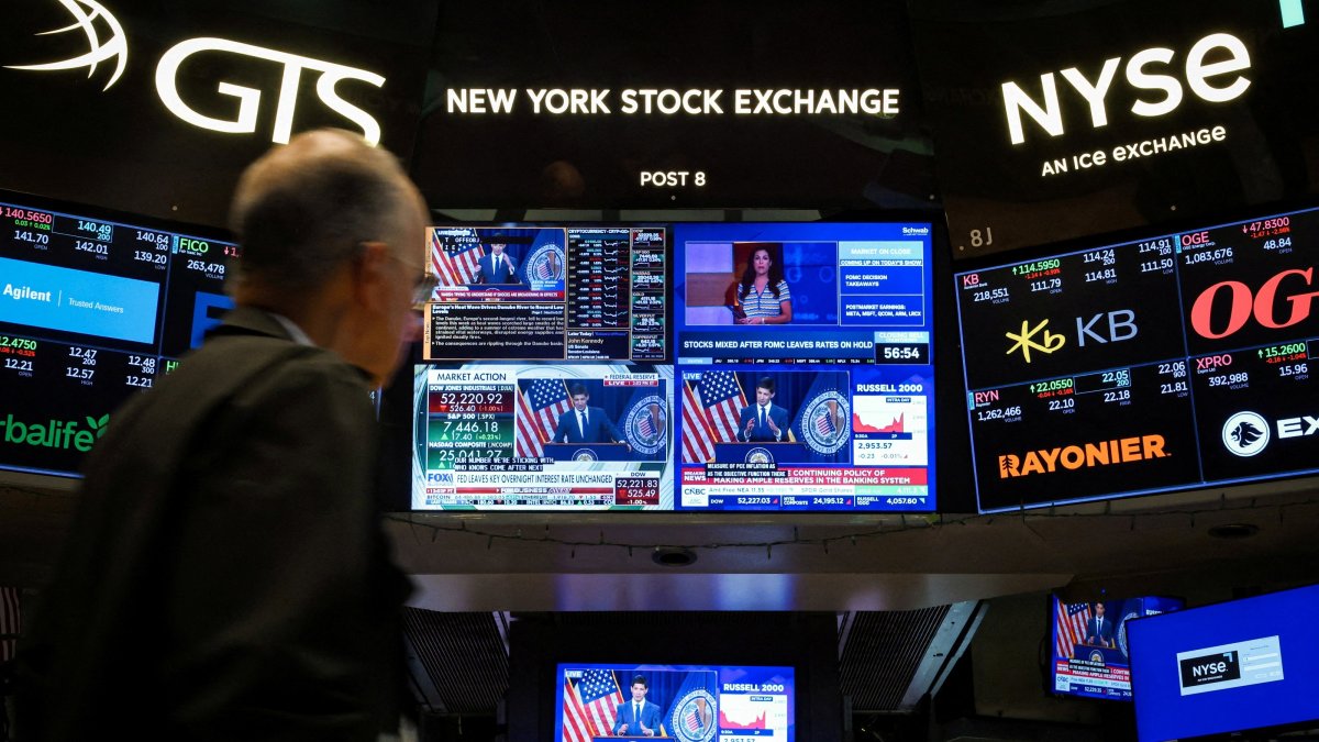 A trader works, as screens broadcast a press conference by U.S. Federal Reserve Chair Kevin Warsh following the Fed rate announcement, on the floor of the New York Stock Exchange (NYSE) in New York City, U.S., July 29, 2026. (Reuters File Photo)